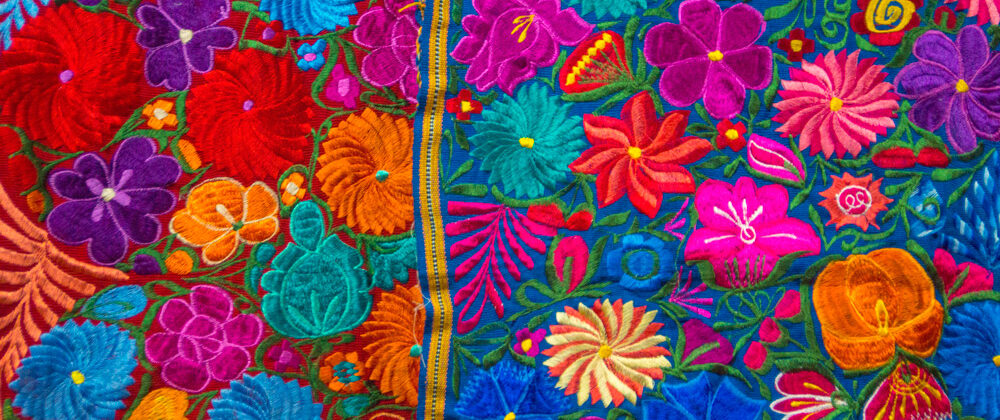 decorative embroidered fabric with bright blue, magenta, green, yellow, and red.